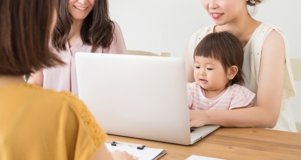 パソコンを囲む女性と赤ちゃん