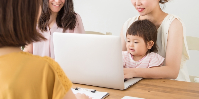 パソコンを囲む女性と赤ちゃん
